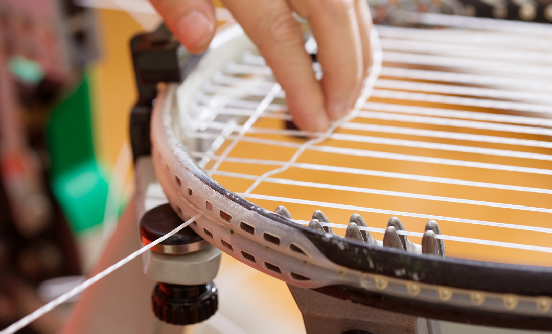 Image of a person stringing a tennis racquet
