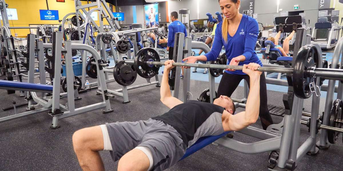 Female personal trainer working with a male client in the gym.