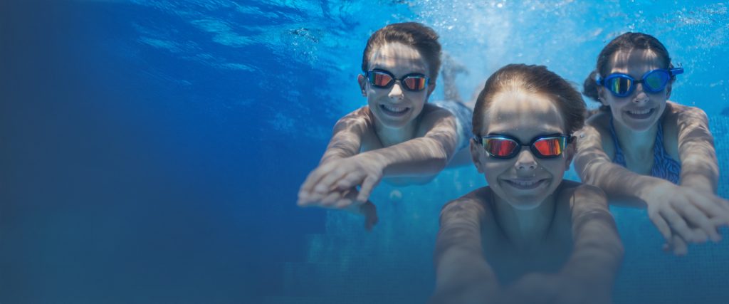 Stock image of kids in swimming pool underwater.