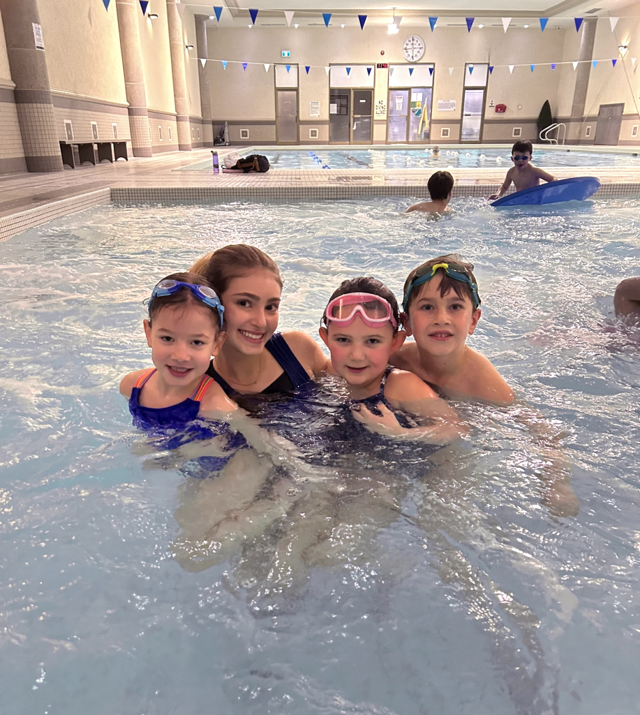 Image of Swim Instructor with three kids in the kids pool at Mayfair West in North York.